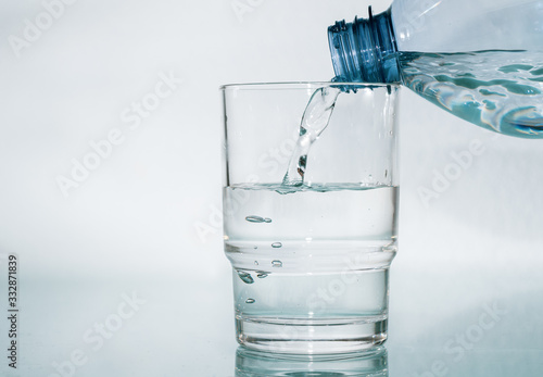 Wasser aus Flasche in das Glas giessen - Plastikflasche