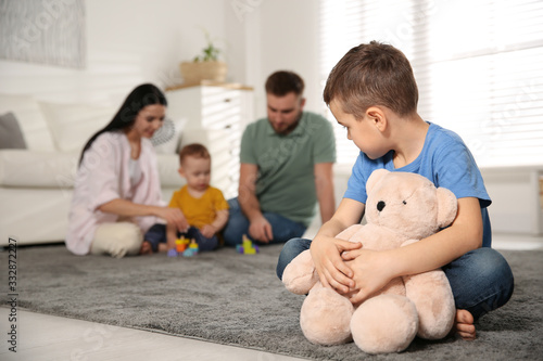 Canvastavla Unhappy little boy feeling jealous while parents spending time with his baby bro