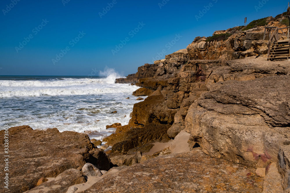 Rocky coastline on the beach - Praia do Magoito at the Atlantic Ocean near Sintra, Portugal.