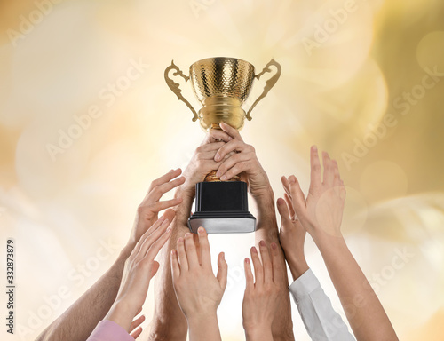 Картината върху платно People with gold trophy cup on color background, closeup
