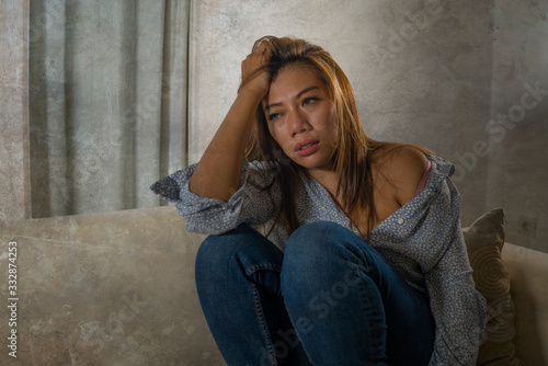 young attractive sad and depressed woman at home feeling worried and scared during covid-19 virus outbreak in home quarantine lockdown suffering stress and panic © TheVisualsYouNeed