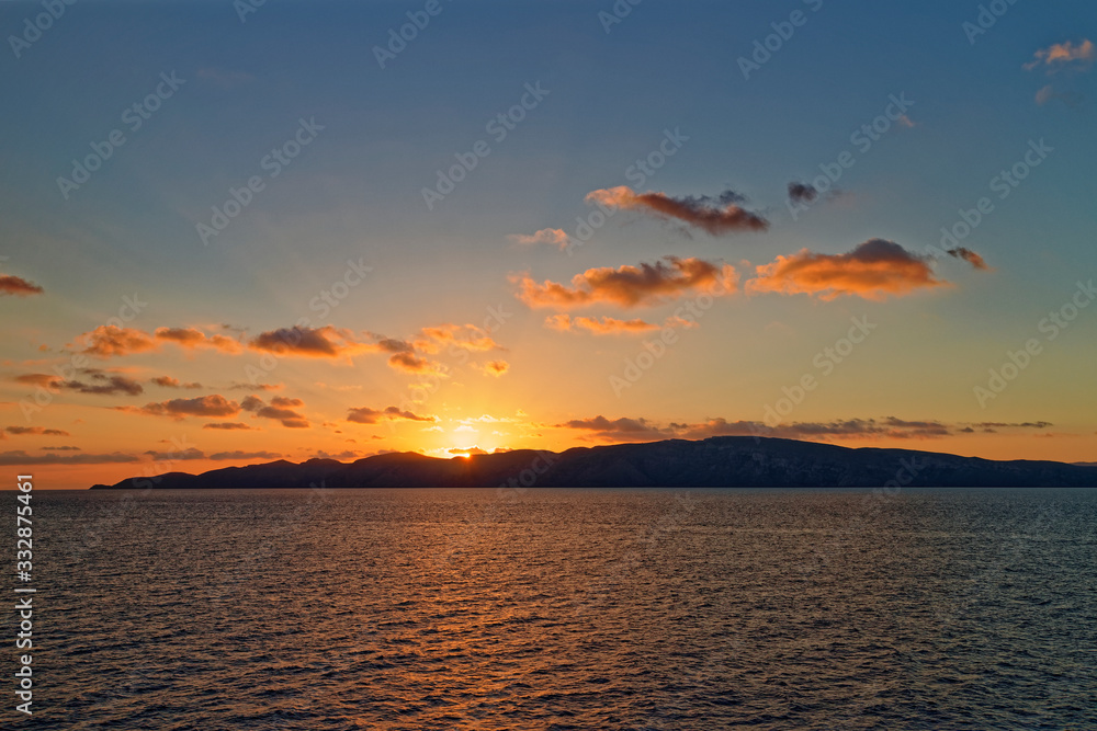 Naklejka premium The Southern tip of the Dardanelles with the Sun rising over the Gallipoli Peninsula and the light reflecting in the calm waters.
