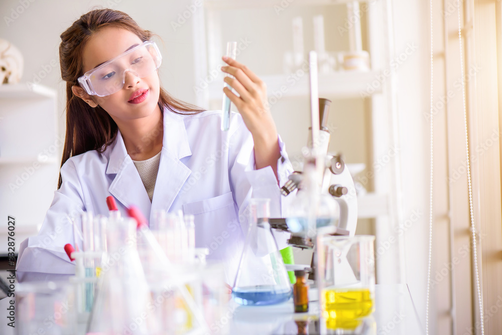 Attractive happiness scientist woman lab technician assistant analyzing sample in test tube at laboratory. Medical, pharmaceutical and scientific research and development concept. Attractive happiness scientist woman lab technician assistant analyzing sample in test tube at laboratory. Medical, pharmaceutical and scientific research and development concept.