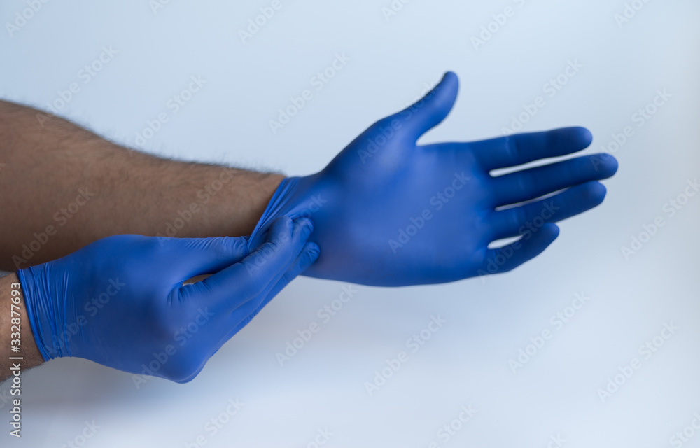 Male doctor hands wearing nitrile blue medical protection gloves. Front view photography on white studio background. Male doctor hands wearing nitrile blue medical protection gloves. Front view photography on white studio background.