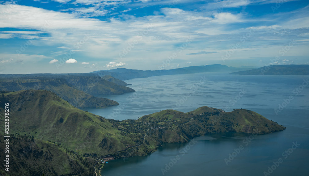 Sunrise at massive lake Toba a caldera of supervolcano a landmark location in north Sumatra, Indonesia. It is a natural 100 kilometer long lake at about 1000 meter altitude high cliff walls