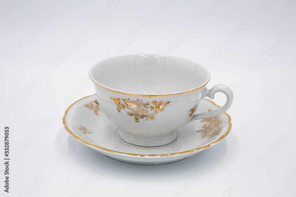 Vintage white tea cup with golden design in classic style isolated on white background