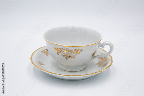 Vintage white  tea cup with golden design in classic style isolated on white background