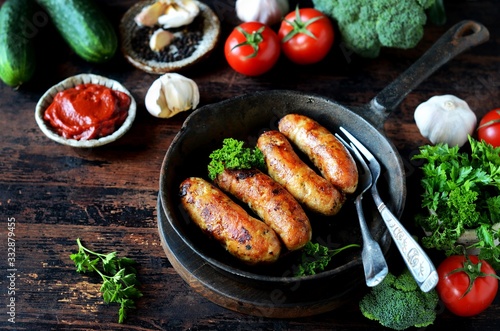 Homemade chicken (turkey) sausages fried in a pan. picnic. rustic