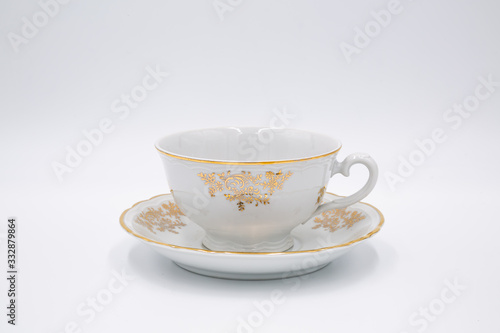 Vintage white tea cup with golden design in classic style isolated on white backg