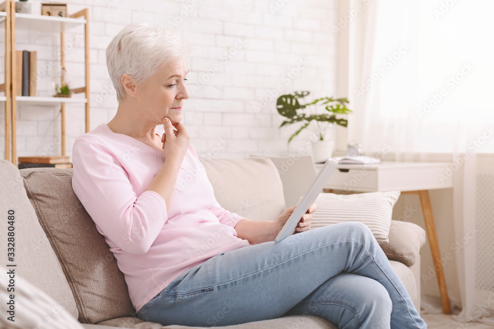 Worried senior woman reading Covid-19 news articles Worried senior woman reading Covid-19 news articles