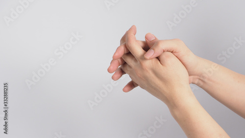 Male model is interlace fingers and continue rubbing on white background. photo