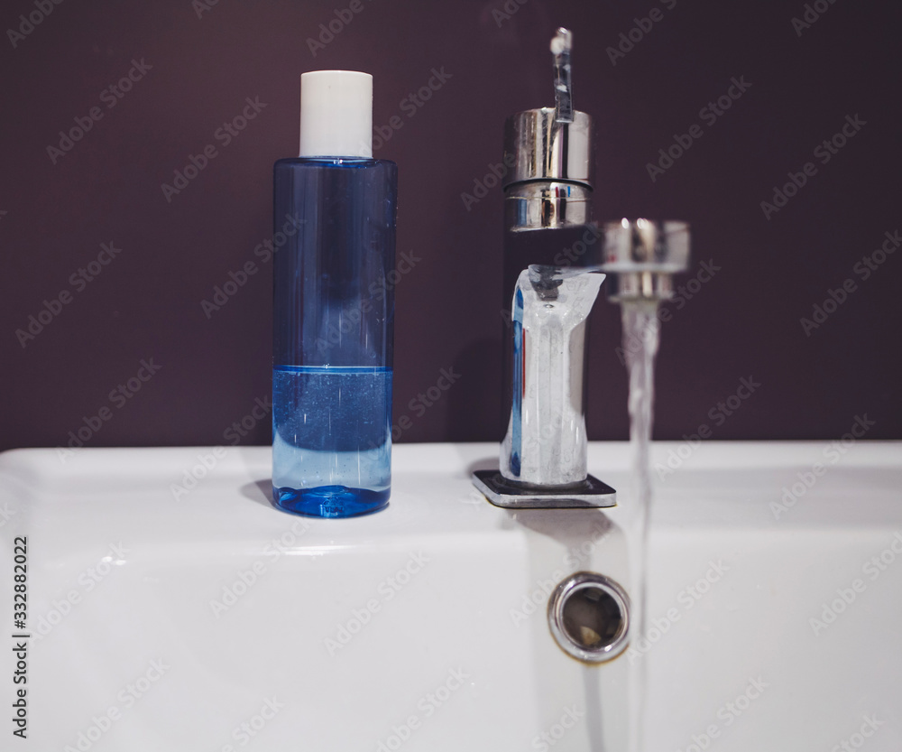 Interior of bathroom with sink basin faucet and liquid soap Interior of bathroom with sink basin faucet and liquid soap