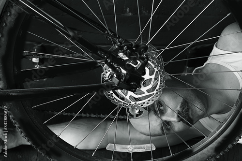 vintage portrait of a mustachioed man repairing a bicycle wheel, eccentric hipster