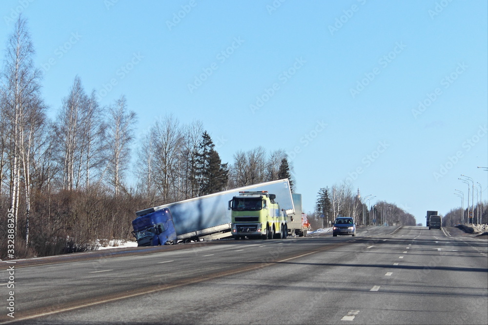 Spring road accident, damaged truck in the roadside ditch on spring day, speed limit violation