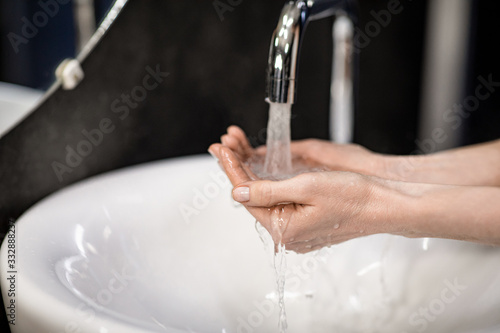 Unrecognizable Woman Washing Hands During Pandemic In Bathroom Indoor, Closeup