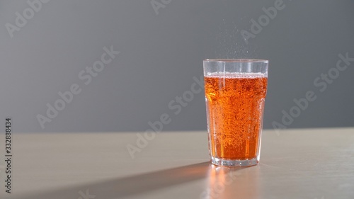 Orange carbonated drink in a glass. Orange soda fresh and cold yellow lemonade drink.