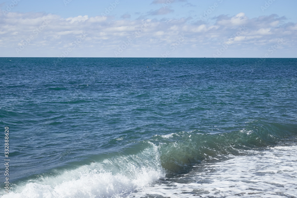 Fototapeta premium Amazing landscape of endless blue sea with waves and foam under boundless sky on sunny summer day