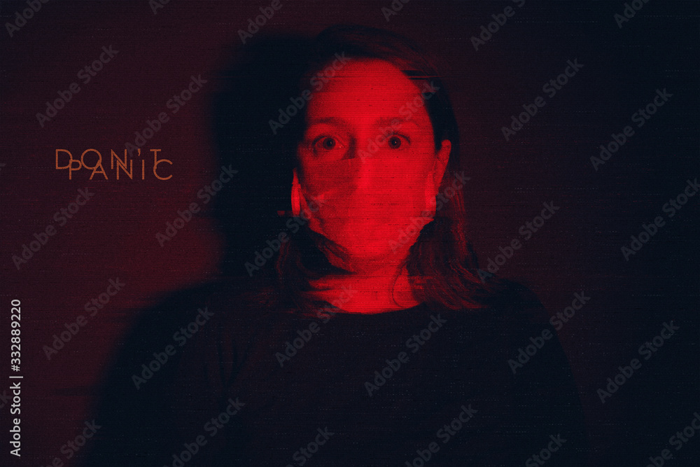 White Adult Woman wearing medical mask looking scared and afraid of coronavirus threat in black background and redlight with glitch effect. Text Don't Panic on background. White Adult Woman wearing medical mask looking scared and afraid of coronavirus threat in black background and redlight with glitch effect. Text Don't Panic on background.