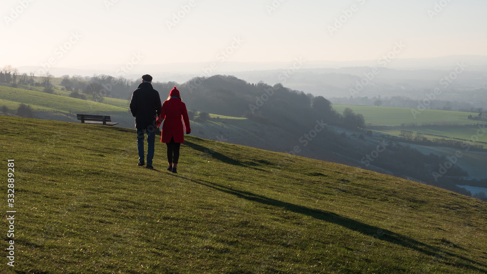 A couple walking on the edge of Salisbury Plain above Westbury in late afteroon