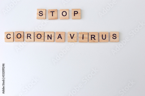 Inscription Stop Coronavirus on a white background with wooden letters lined