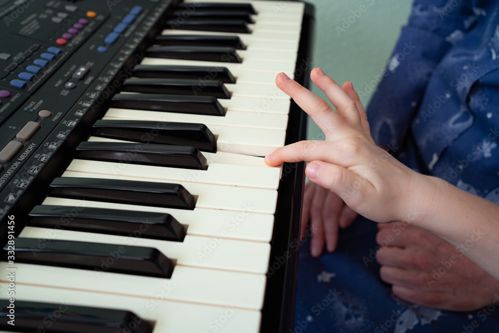 Fototapeta premium child hands black white piano keys synth. close-up