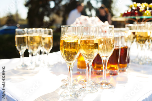 Elegant glasses with champagne standing on serving table during celebration