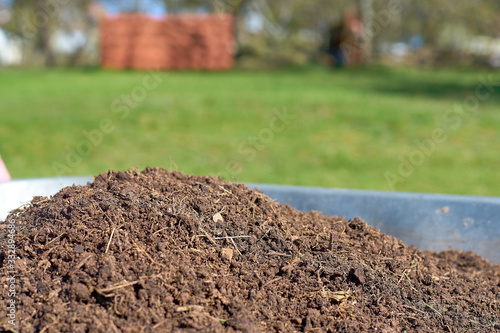 Wallpaper Mural Fresh compost in a wheelbarrow with a green meadow in the background Torontodigital.ca