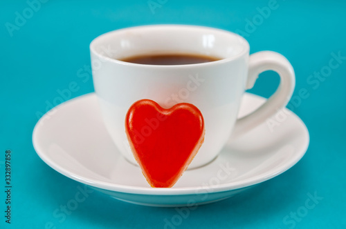 trendy minimal close up of white cup of coffee with red heart jelly candy