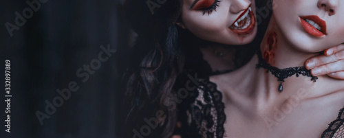 Artwork close up portrait evil medieval vampire woman bites tender cute girl princess. Drop blood red sexy lips. Bloody scary wound bite on neck. Woman's Vampire mouth teeth fangs. Horror bloddy kiss photo