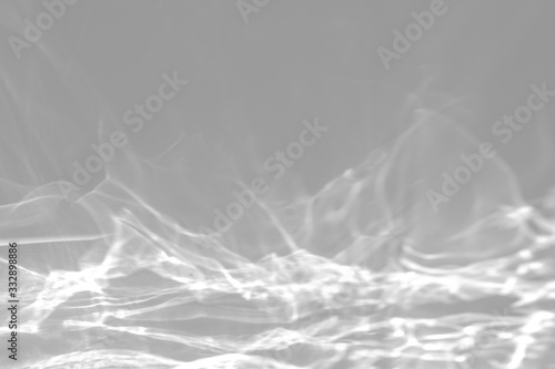 Blurred Water texture overlay effect for photo and mockups. Organic drop diagonal shadow and light caustic effect on a white wall. Shadows for natural light effects
