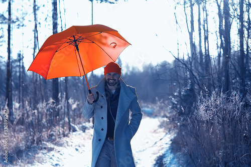 winter walk with an umbrella / man in a coat with an umbrella, walk against the backdrop of the winter landscape, winter view