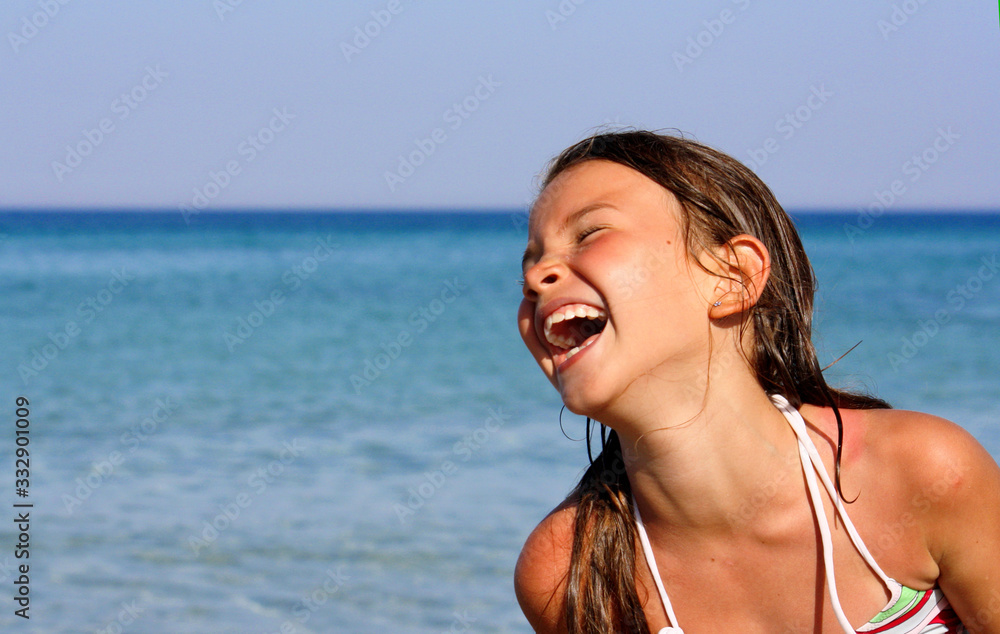 BAMBINA IN SPIAGGIA RIDENDO