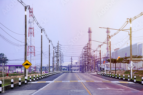 Fototapeta Naklejka Na Ścianę i Meble -  Industrial factory plant with flare light from sunset