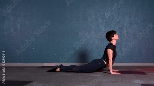 girl doing exercise in the yoga room. She smoothly does the dog exercise face up.