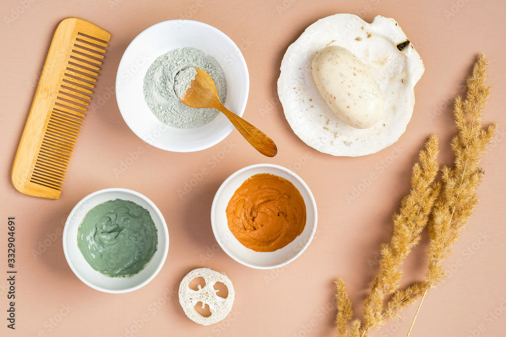 Homemade facial clay masks and SPA natural organic cosmetic products on peach background. Face skin care and beauty treatment concept. Flat lay, top view. Homemade facial clay masks and SPA natural organic cosmetic products on peach background. Face skin care and beauty treatment concept. Flat lay, top view.