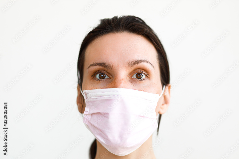 white caucasian woman wearing medical mask looking at camera on white background wall white caucasian woman wearing medical mask looking at camera on white background wall