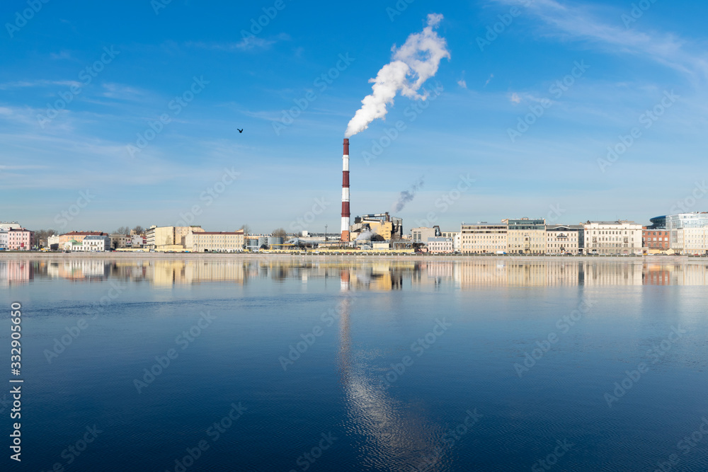 Industrial St. Petersburg - March 17, 2020 Heat station pipes, smoke. Smoking chimneys on the blue sky background. The heating season, modern global warming. Industrial St. Petersburg - March 17, 2020 Heat station pipes, smoke. Smoking chimneys on the blue sky background. The heating season, modern global warming.