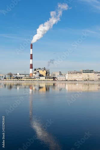 Industrial St. Petersburg. Heat station pipes, smoke. Smoking chimneys on the blue sky background. The heating season, modern global warming.