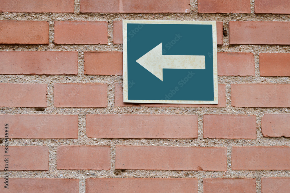 Background with a brick wall with a metal sign with an arrow Background with a brick wall with a metal sign with an arrow