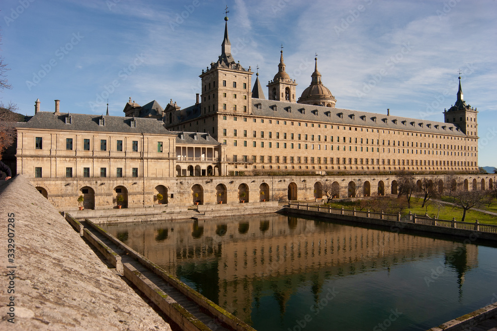 Vista de la fachada sur del Real Monasterio de San Lorenzo de El Escorial reflejada en el estanque.