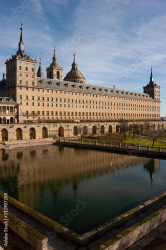 Toma vertical de la fachada sur Real Monasterio de San Lorenzo de El Escorial reflejada en el estanque.