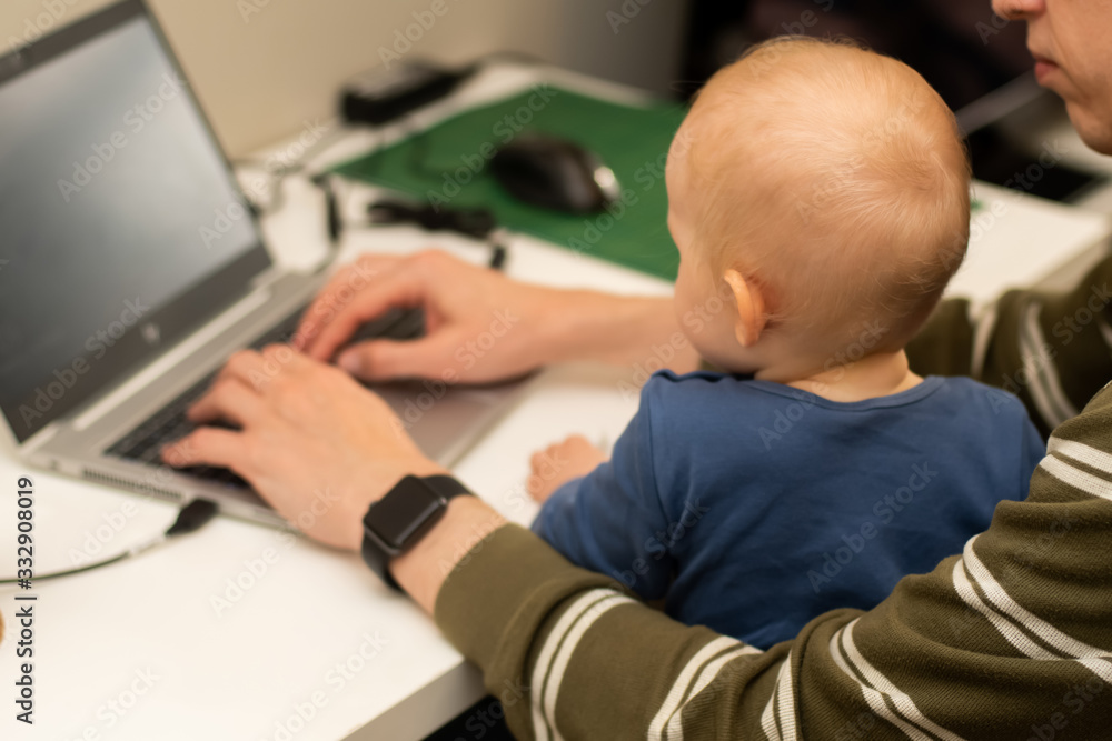 Coronavirus lockdown work from home concept. Close op of hands of a man working from home with the baby on his laps. Coronavirus lockdown work from home concept. Close op of hands of a man working from home with the baby on his laps.