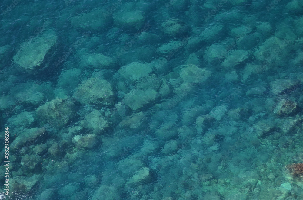 The clear water of the Adriatic Sea. The rocky bottom is visible.
