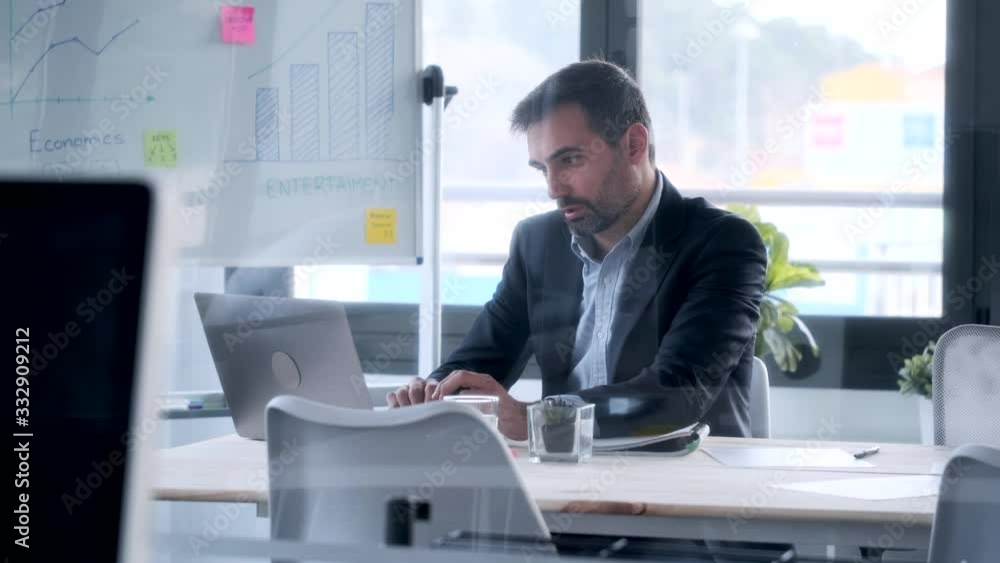 Video of handsome businessman working with laptop while sitting in the office. Video of handsome businessman working with laptop while sitting in the office.