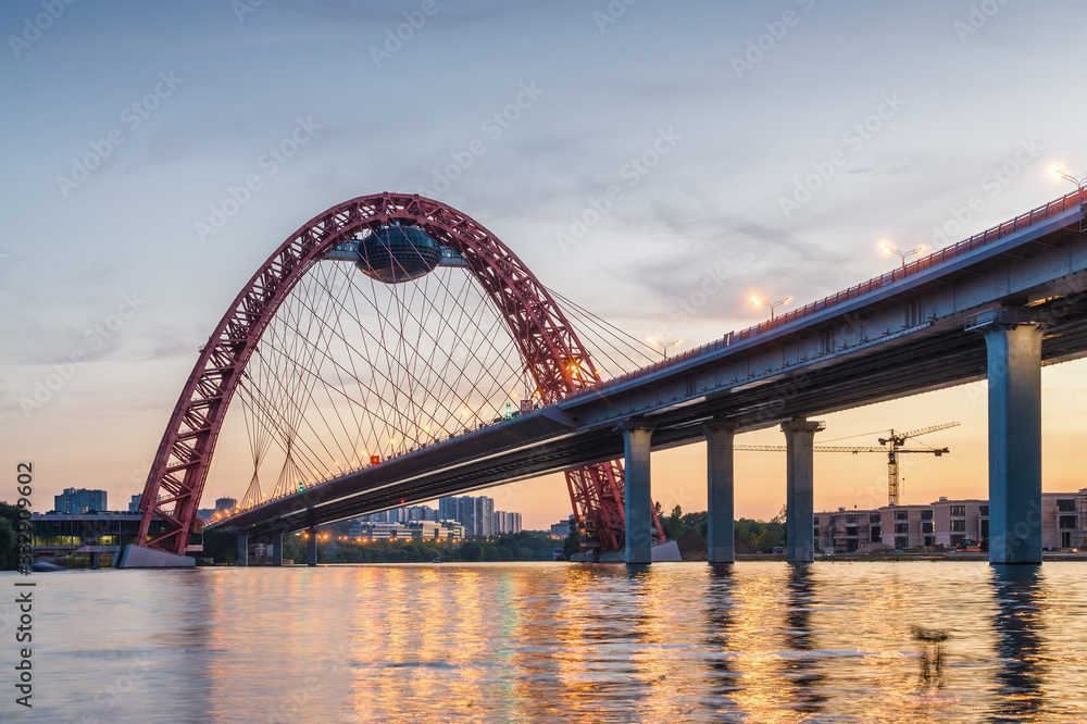 Obraz premium Sunset view of Picturesque bridge with big red arch over the Moscow river, Moscow, Russian Federation.
