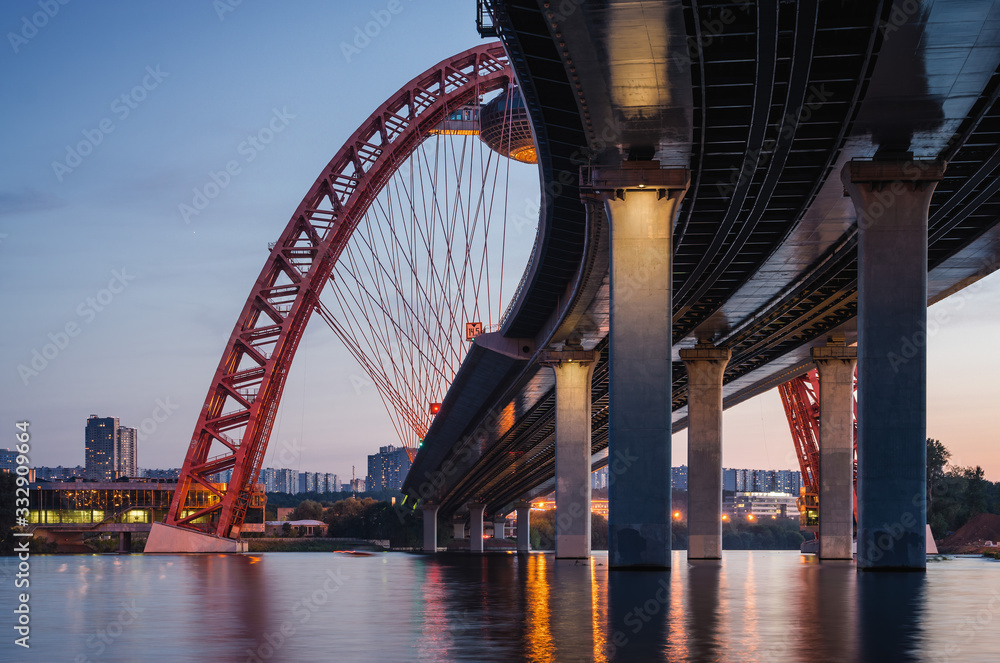 Obraz premium Sunset view of Picturesque bridge with big red arch over the Moscow river, Moscow, Russian Federation.