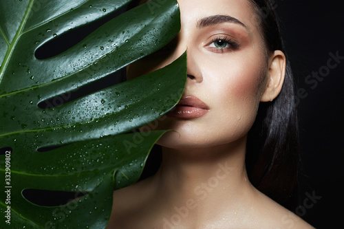 beautiful wet girl in palm leaves. Natural cosmetics photo