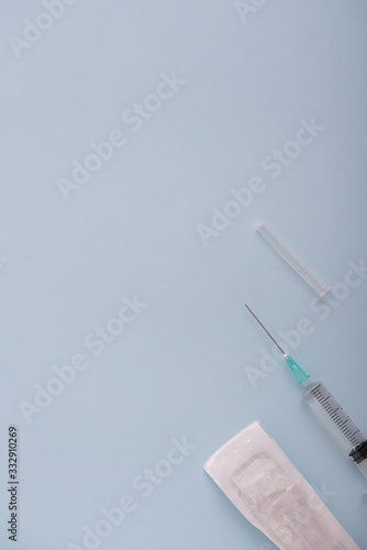 jeringuilla o vacuna sobre fondo azul con espacio en vertical