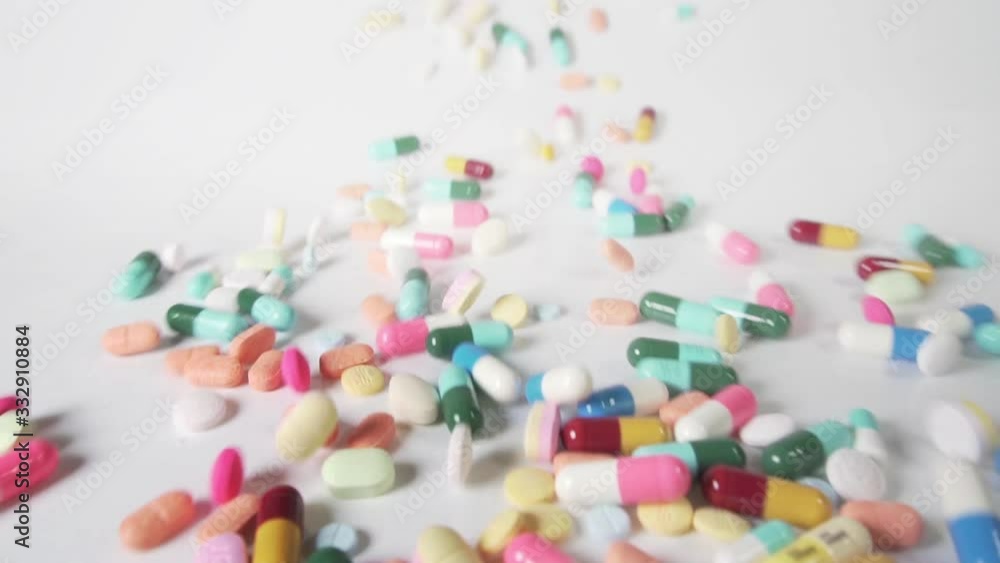 Slow motion shot of pills falling on white background Slow motion shot of pills falling on white background