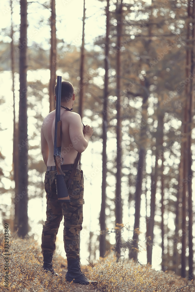 hunting man / hunter with a gun hunting in the autumn forest, yellow trees landscape in the taiga hunting man / hunter with a gun hunting in the autumn forest, yellow trees landscape in the taiga